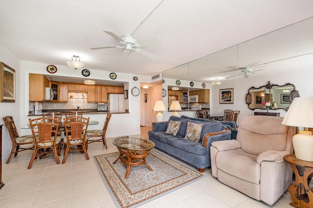 tiled living room featuring ceiling fan and a textured ceiling