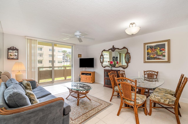 living room featuring ceiling fan, a wall of windows, a textured ceiling, and light tile patterned floors