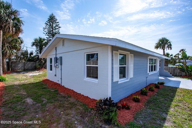 view of side of home with a yard