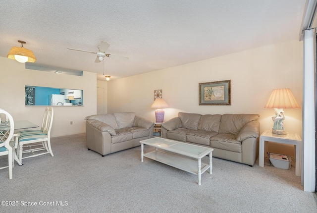 carpeted living room with ceiling fan and a textured ceiling