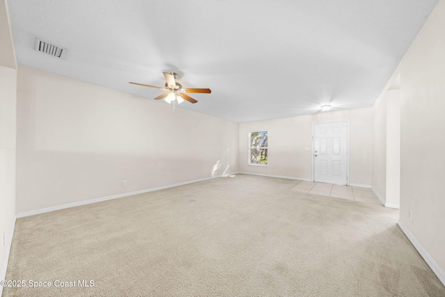 spare room featuring light colored carpet and ceiling fan