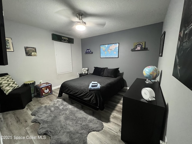 bedroom with ceiling fan, a textured ceiling, and hardwood / wood-style flooring