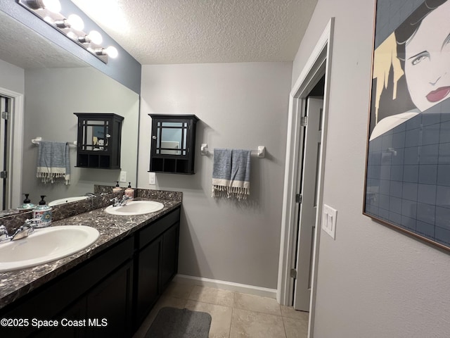 bathroom with tile patterned floors, vanity, and a textured ceiling