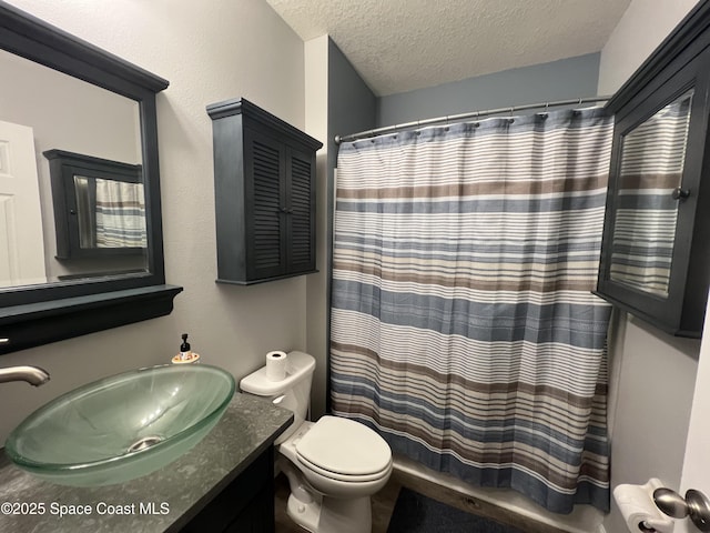 bathroom featuring curtained shower, vanity, a textured ceiling, and toilet