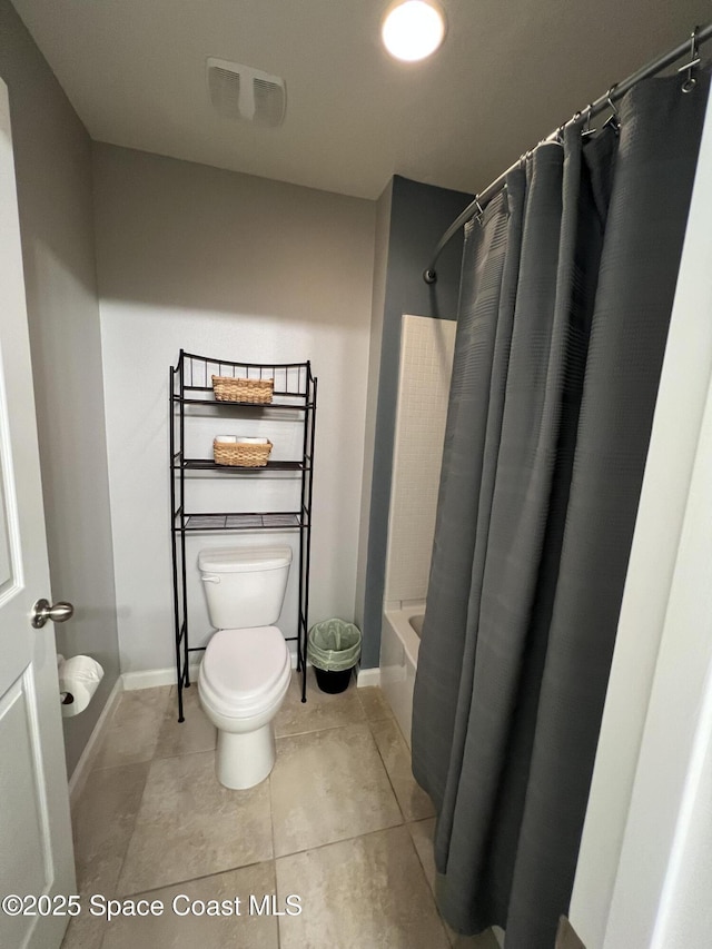 bathroom with tile patterned flooring, shower / bathtub combination with curtain, and toilet