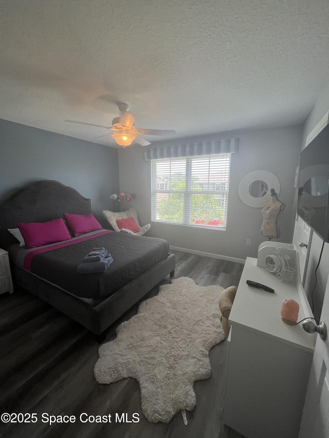 bedroom with a textured ceiling, dark hardwood / wood-style flooring, and ceiling fan