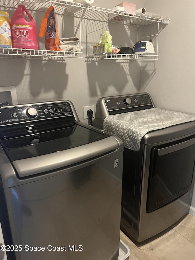 laundry area with separate washer and dryer and tile patterned floors