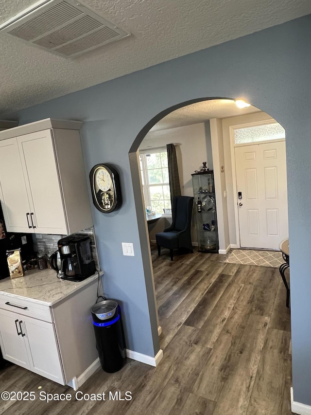 kitchen featuring white cabinets, dark hardwood / wood-style floors, decorative backsplash, and a textured ceiling