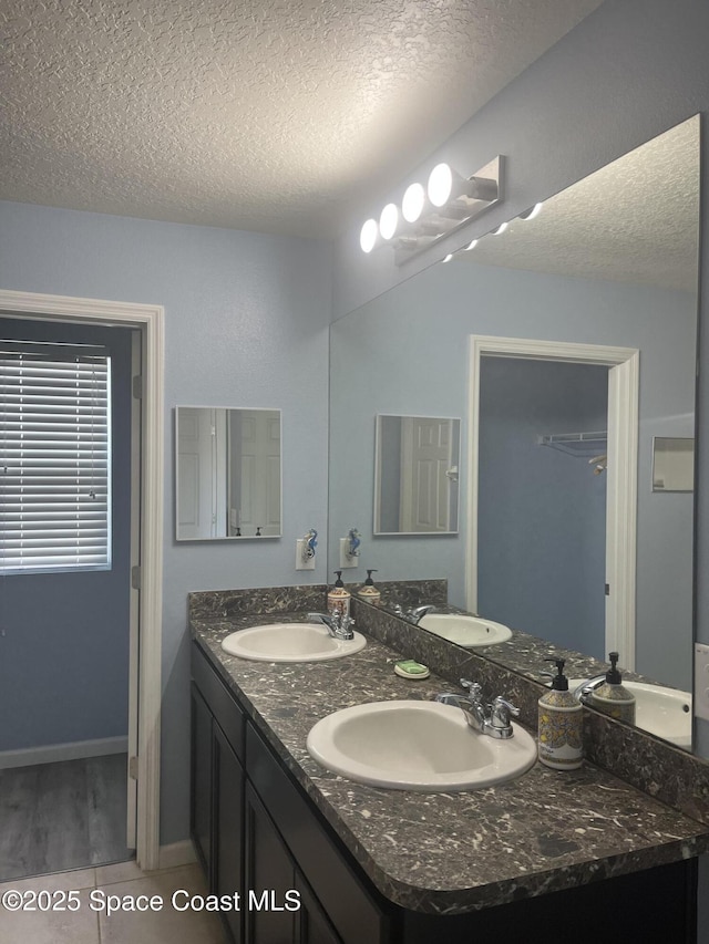 bathroom featuring vanity, a textured ceiling, and tile patterned flooring