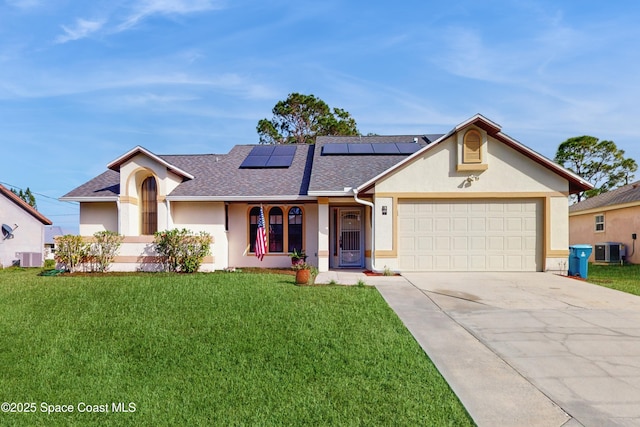 ranch-style house featuring central air condition unit, a garage, a front yard, and solar panels