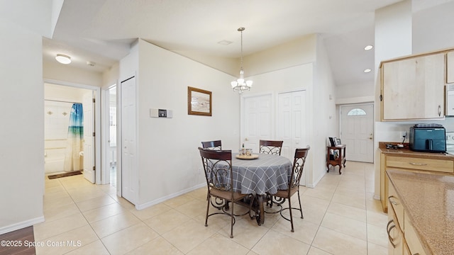 dining space with light tile patterned floors and a notable chandelier