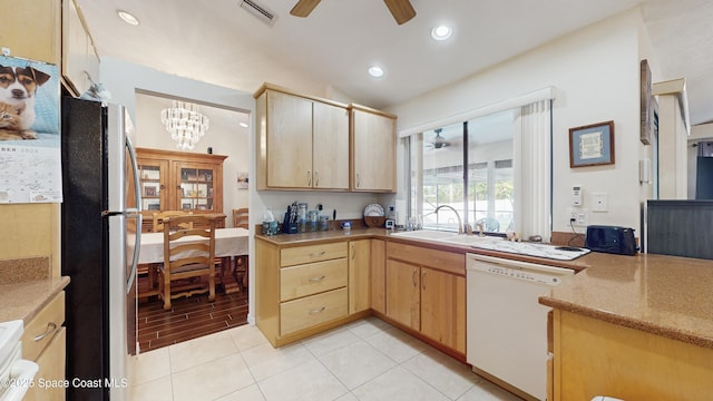 kitchen with dishwasher, light brown cabinets, sink, and stainless steel refrigerator