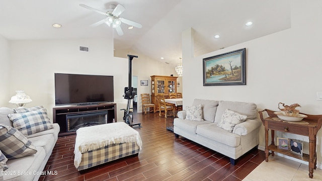 living room with ceiling fan, a fireplace, and vaulted ceiling