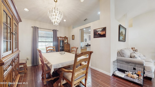 dining area with a chandelier and vaulted ceiling