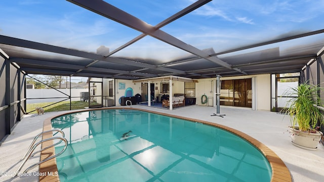 view of swimming pool featuring glass enclosure and a patio