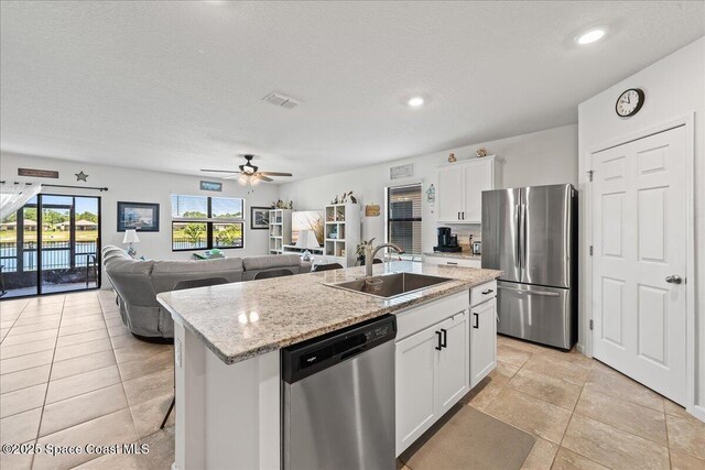 kitchen featuring white cabinetry, sink, ceiling fan, stainless steel appliances, and a kitchen island with sink