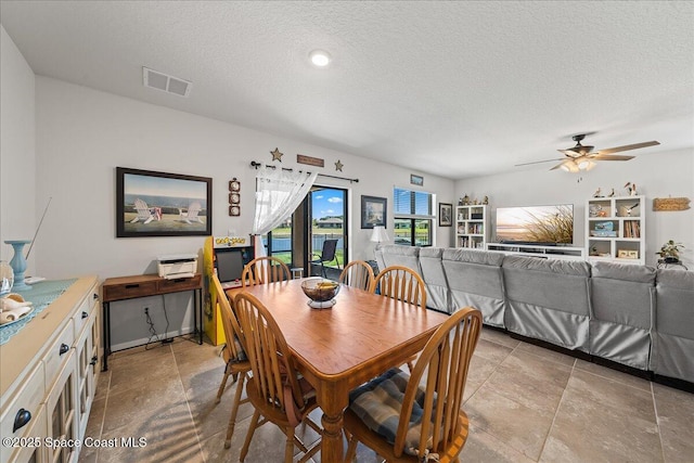 dining room with a textured ceiling and ceiling fan