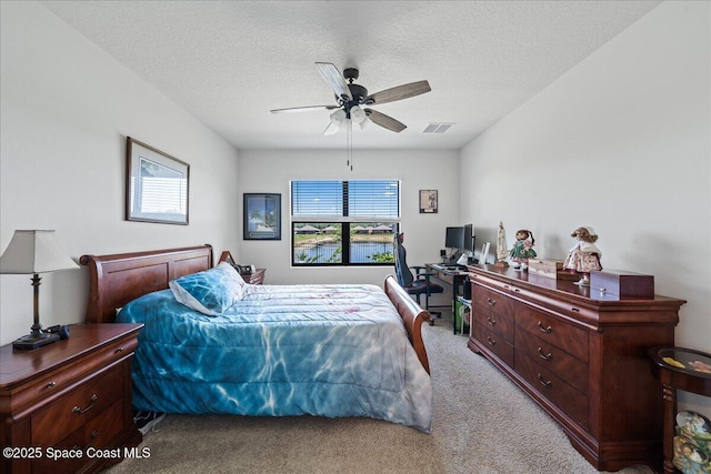 bedroom with light carpet, a textured ceiling, and ceiling fan