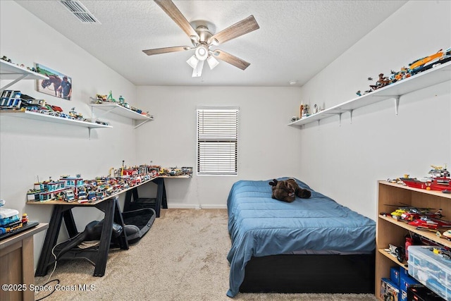 bedroom featuring light carpet, a textured ceiling, and ceiling fan