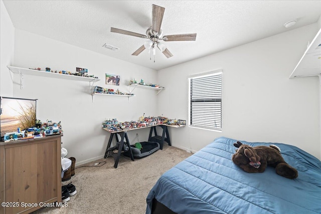 bedroom featuring a textured ceiling, ceiling fan, and light carpet