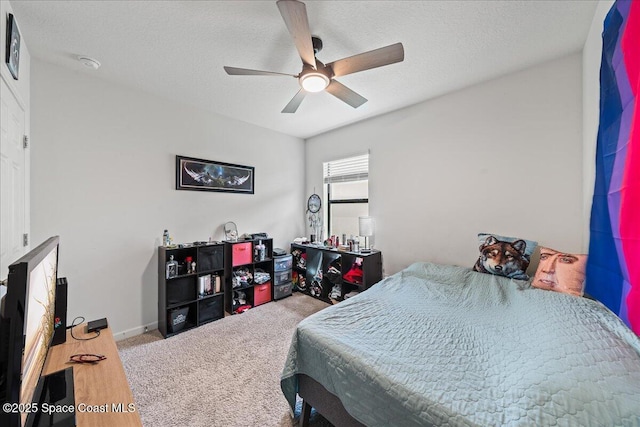 carpeted bedroom with ceiling fan and a textured ceiling