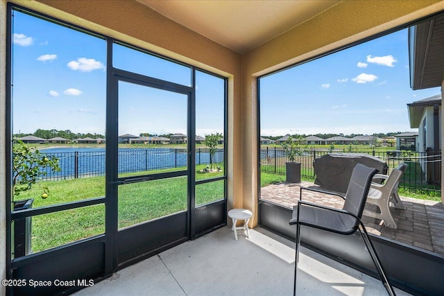 sunroom featuring a water view and plenty of natural light