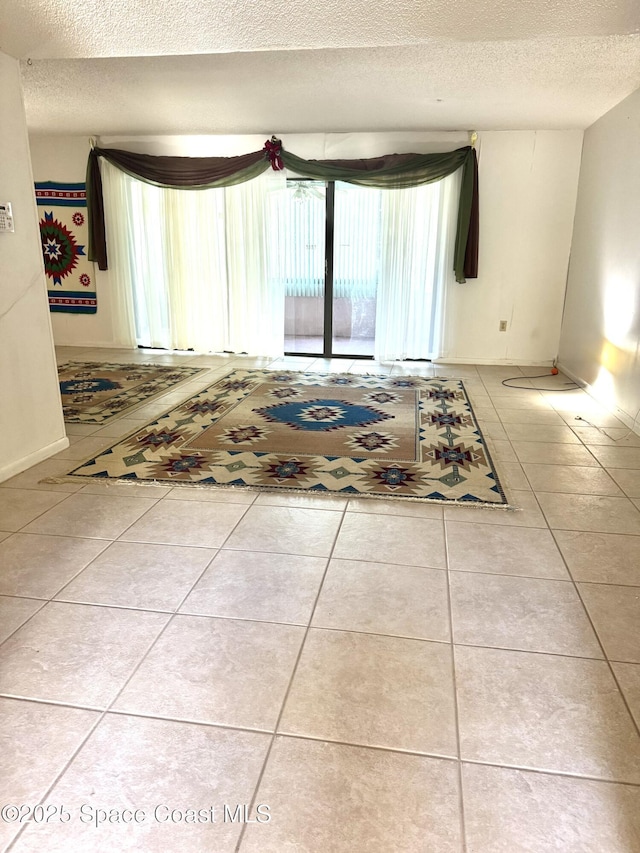 spare room featuring tile patterned floors and a textured ceiling