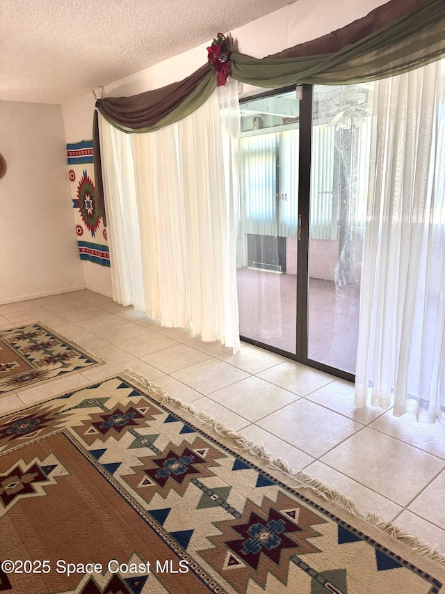 empty room with tile patterned flooring and a textured ceiling