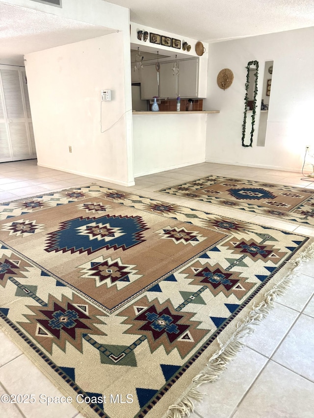 unfurnished living room with tile patterned flooring and a textured ceiling