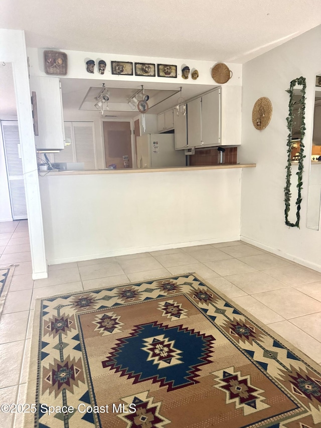 kitchen featuring white refrigerator and light tile patterned flooring