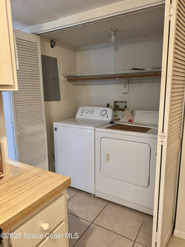 washroom with light tile patterned floors, electric panel, separate washer and dryer, and a textured ceiling