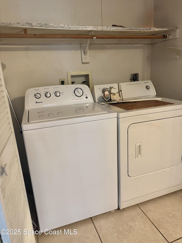 laundry room featuring washer and clothes dryer and light tile patterned floors