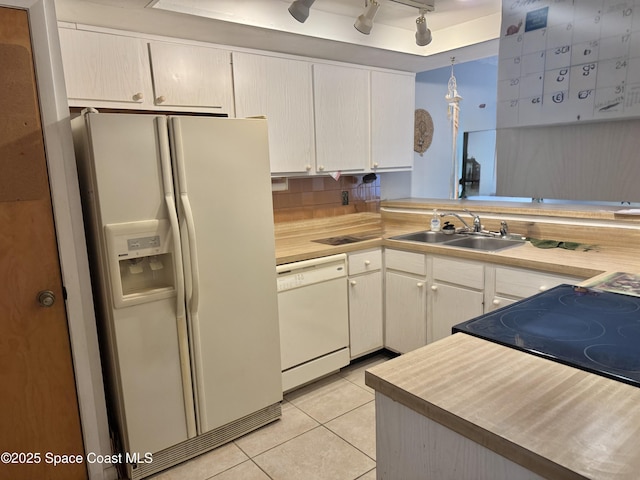 kitchen with white appliances, sink, hanging light fixtures, light tile patterned flooring, and kitchen peninsula