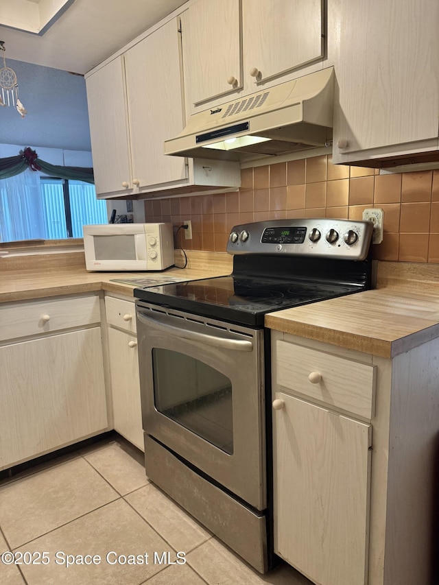 kitchen with light tile patterned flooring, stainless steel range with electric cooktop, and tasteful backsplash