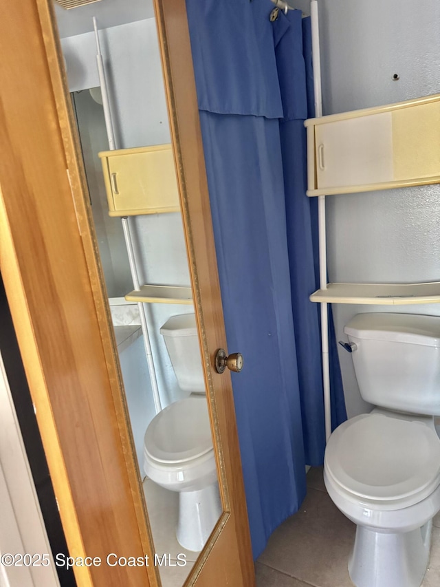 bathroom with tile patterned flooring and toilet