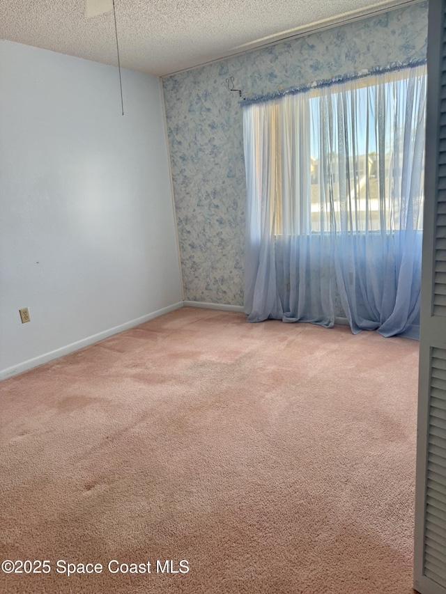 carpeted spare room featuring a textured ceiling