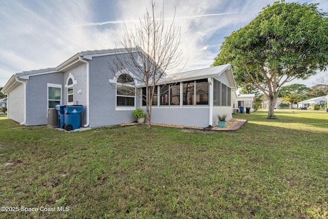 view of property exterior with a lawn and a sunroom