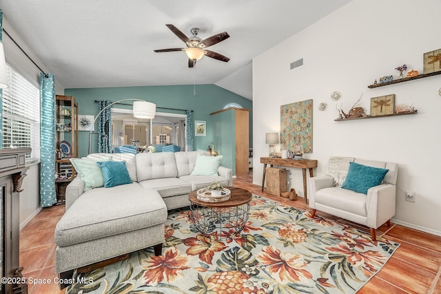 living room featuring ceiling fan, light tile patterned floors, and lofted ceiling