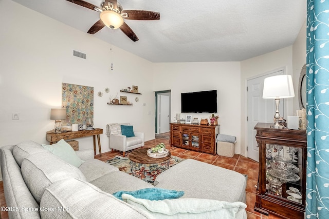 tiled living room featuring ceiling fan and vaulted ceiling