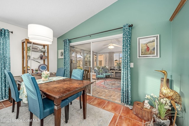 dining space with tile patterned floors, ceiling fan, and lofted ceiling