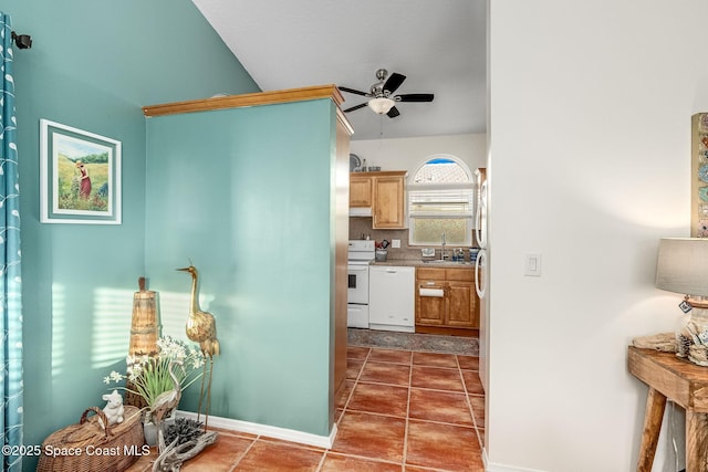 kitchen featuring ceiling fan, sink, white appliances, decorative backsplash, and dark tile patterned flooring