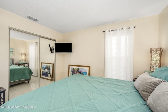 bedroom with a closet and light tile patterned flooring