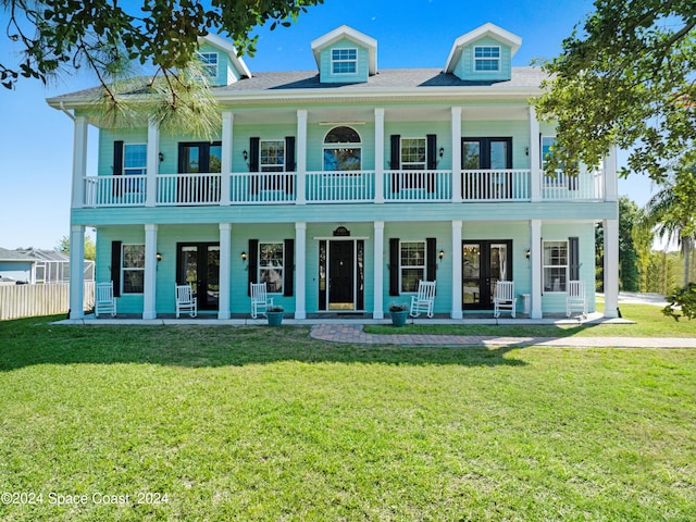 view of front facade with a front yard, a porch, and french doors