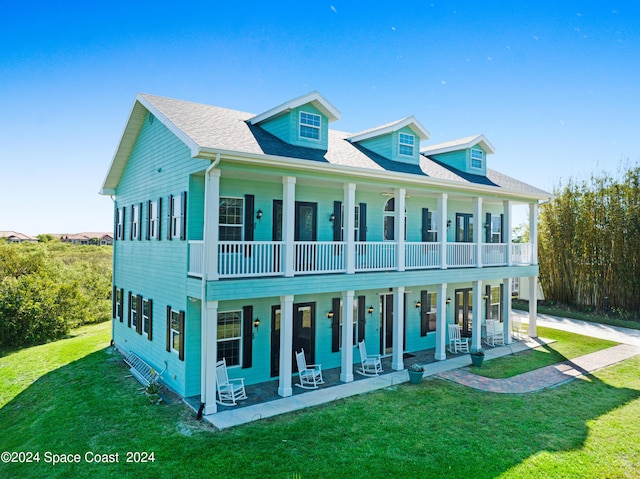 view of front of house with a balcony, a front lawn, and a porch