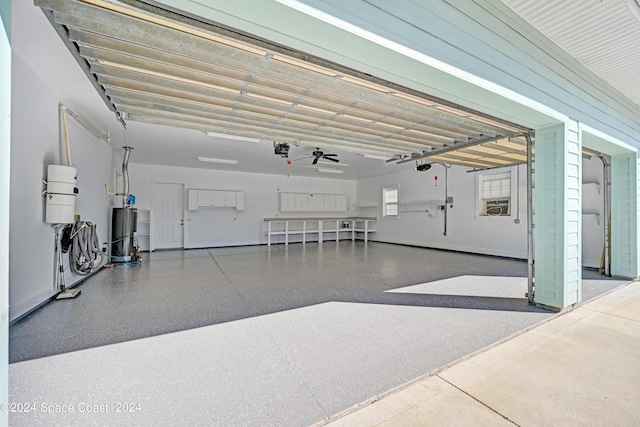 garage with ceiling fan, cooling unit, water heater, and a garage door opener