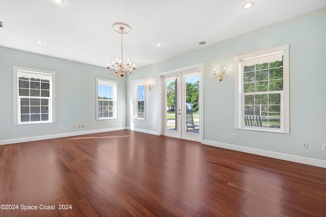 unfurnished room featuring dark wood-type flooring and a notable chandelier