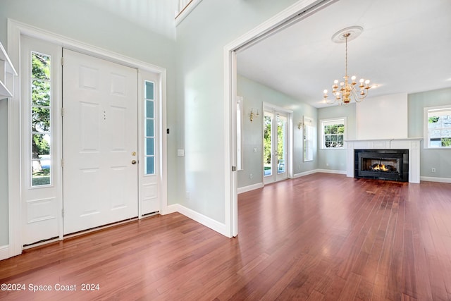 entrance foyer featuring wood-type flooring, a wealth of natural light, and a notable chandelier