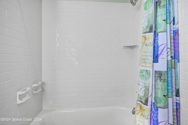 bathroom with shower / bath combo with shower curtain