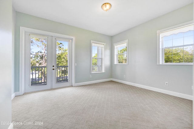 unfurnished room with light carpet and french doors