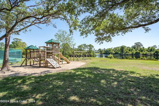 view of jungle gym featuring a lawn and a water view